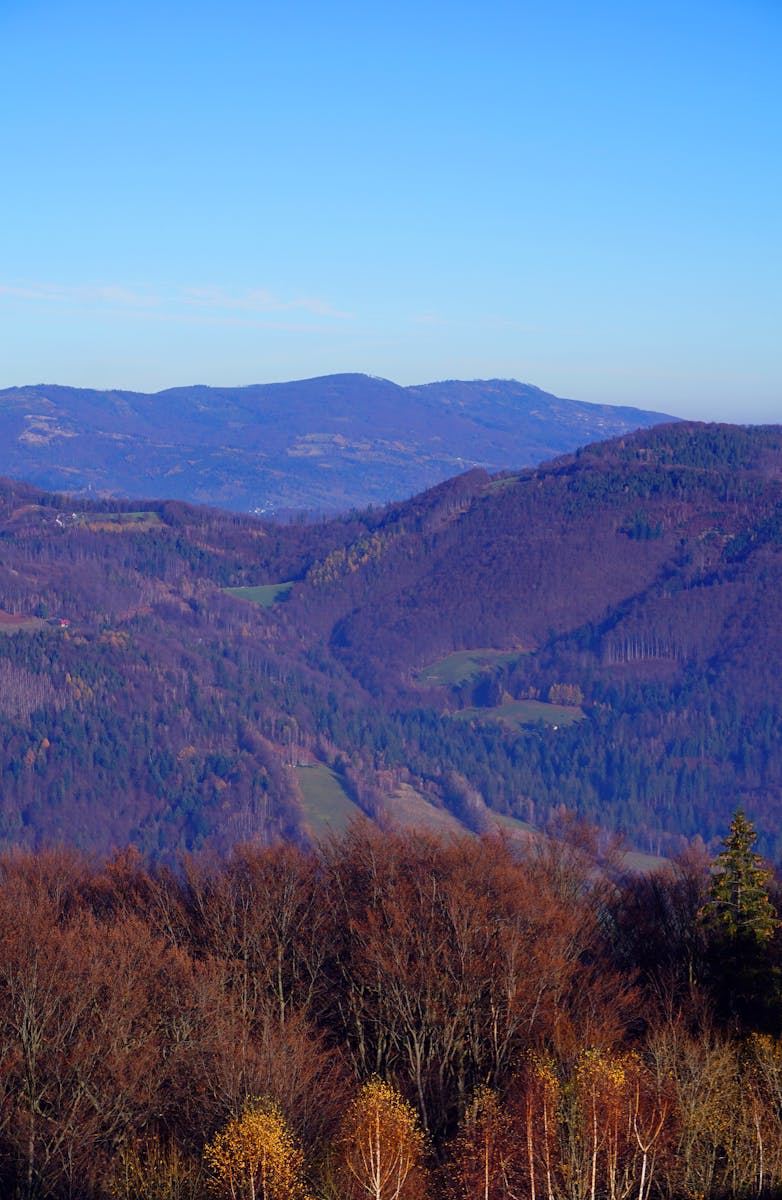 Beautiful autumn mountain landscape in Ustroń, Poland, with vibrant colors and clear blue sky.