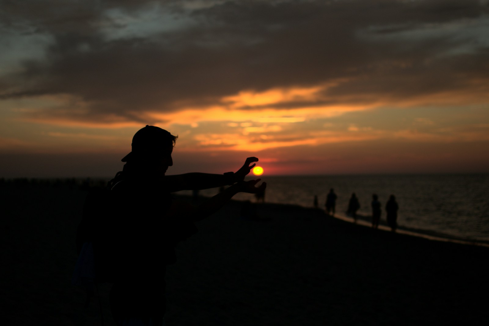 Photo by Mateusz Bajdak silhouette of man sitting on rock near sea during sunset