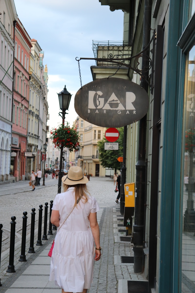 a person in a white dress walking down a sidewalk