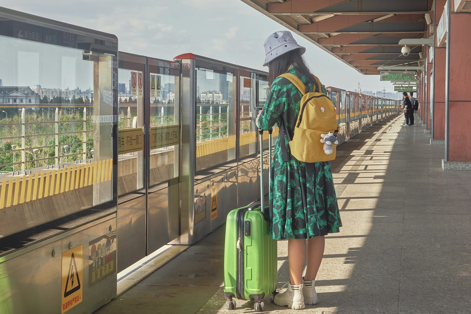 woman in green and blue dress standing beside train during daytime