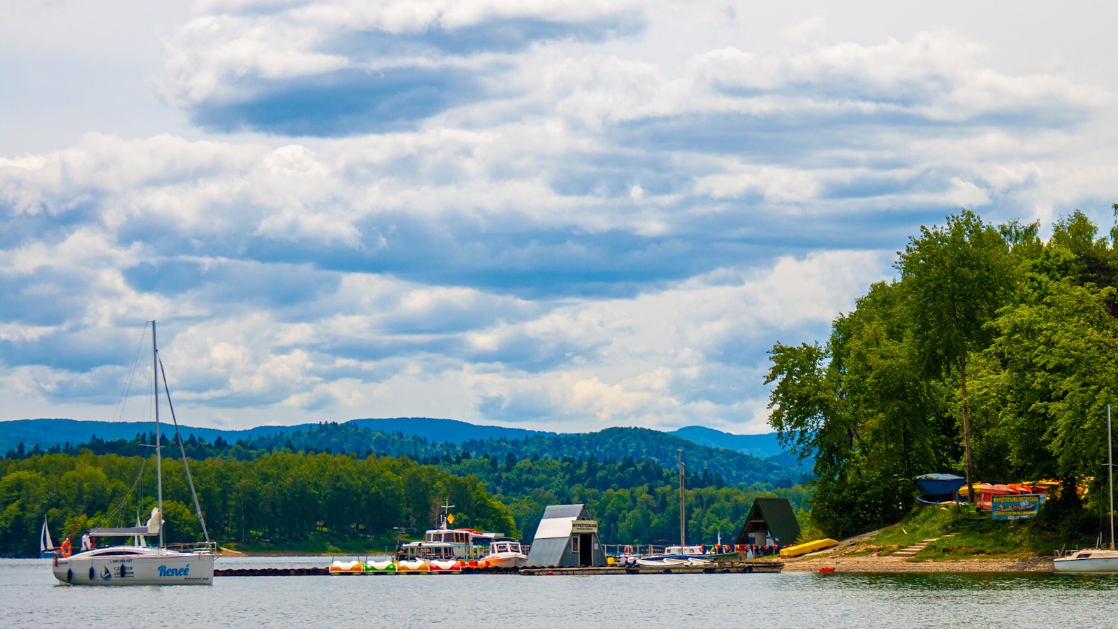 Photo by NISZOgen a body of water surrounded by trees and boats