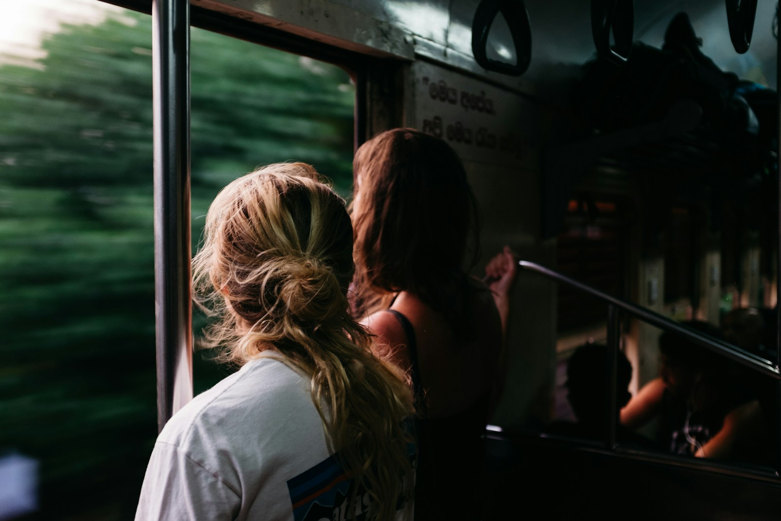 Photo by Fredrik Öhlander two person standing on train window